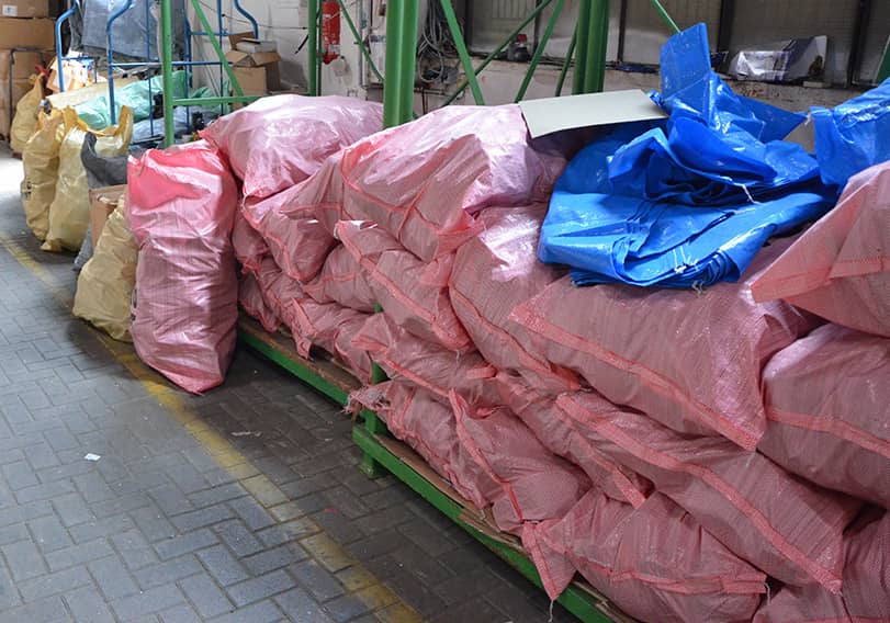 Rosa und gelbe Säcke gefüllt mit Schuhen und Textilien